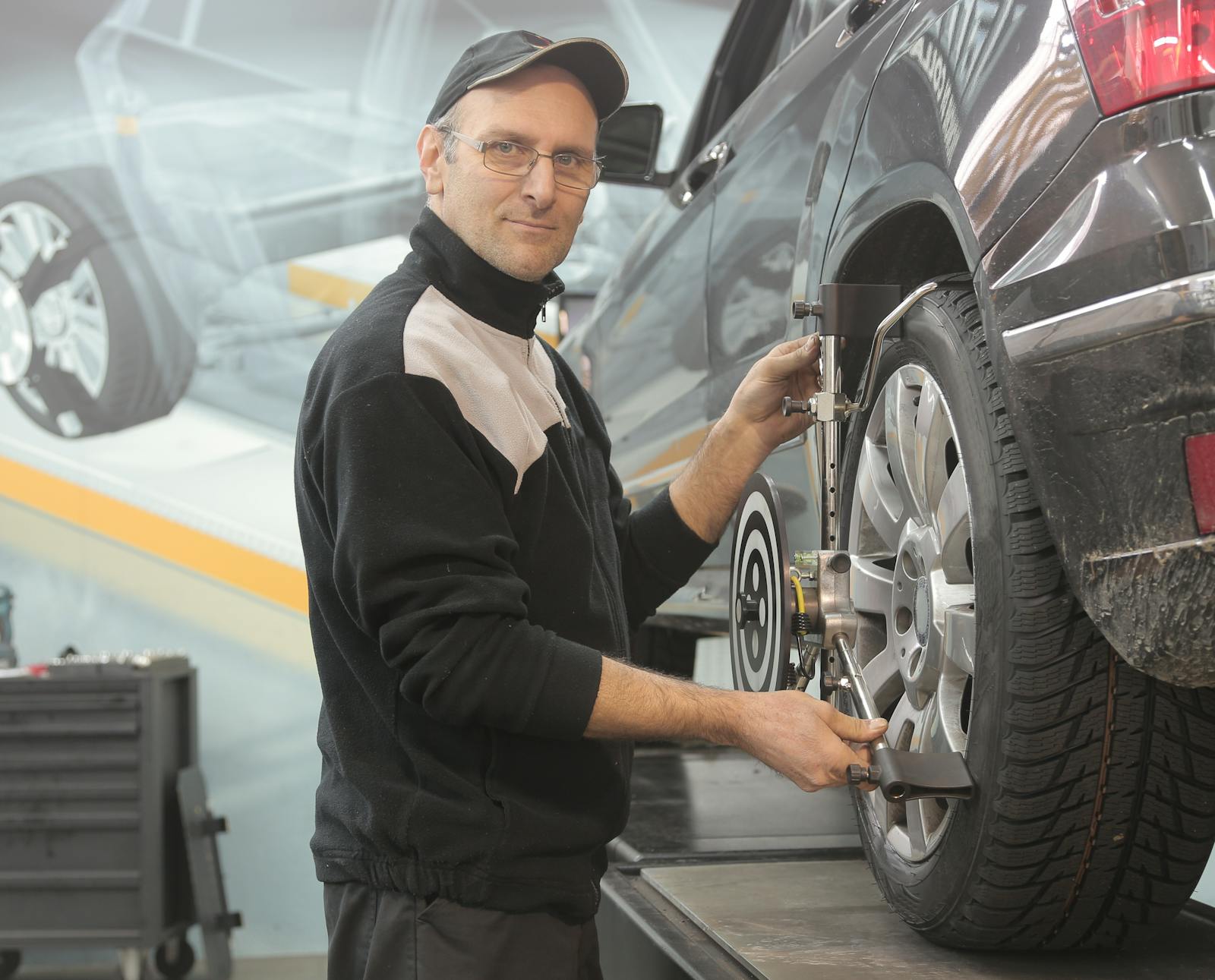 Technician mounting Hunter alignment target on a wheel
